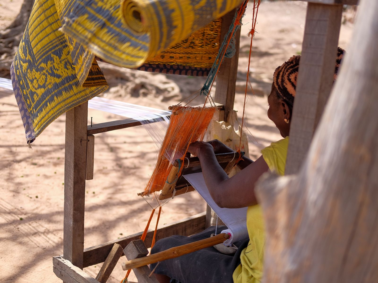 Hands weaving aso-oke at a loom
